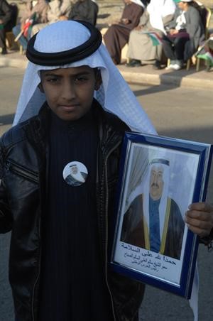 طفل يحمل صورة الشيخ سالم العلي
