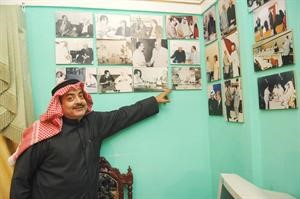 احمد ابوسيدو مشيرا الى مجموعة من صور والده مع شخصيات كويتية وعالمية﻿