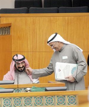 النائب شعيب المويزري يحمل ملفاته ممازحا وزير الشؤون د محمد العفاسي خلال الجلسة امسمتين غوزال