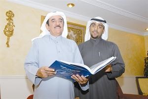 اللواء جاسم المنصوري يطالع كتابا في الادارة وبجواره نجله المحامي عبدالله﻿