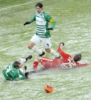 لاعب بايرن ميونيخ توماس مولر الى اليمين يسقط على ارضية الملعب التي غطتها الثلوج في المباراة مع فورث﻿