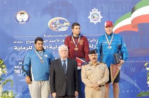 الرامي خالد المضف على منصة التتويج بالمركز الثالث بعد تقليده الميدالية من اللواء محمود الدوسري