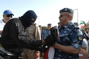 اللواء سليمان الفهد يتسلم علم الكويت من احد رجال القوات الخاصة بعد انتهاء العرض