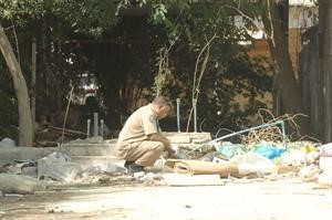 رجل امن تابع للادلة الجنائية يعاين مسرح الجريمة