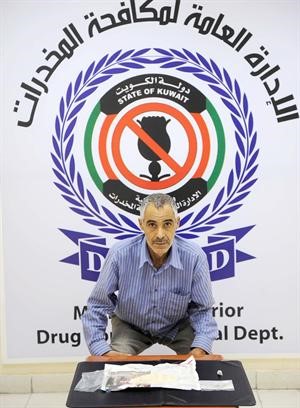 الدلال الايراني وامامه كمية الهيروين المضبوطة