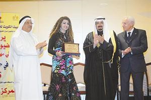 النجمة الاماراتية هدى الخطيب تحمل درع تكريمها﻿