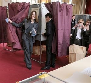 الرئيس الفرنسي نيكولا ساركوزي وزوجته كارلا بروني لدى خروجهما من غرفة الاقتراع	اپ﻿