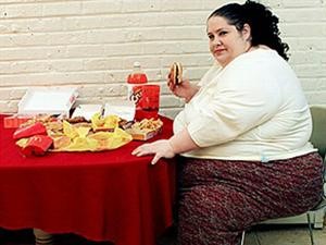 سيمبسون تلتهم الطعام ليزيد وزنها وفي الصورة الاخرى تتوسط فتاتين اثناء البرنامج
﻿
