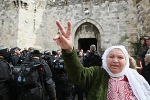 فلسطينية بجوار قوات الاحتلال ترفع يدها بعلامة النصر في القدس	 افپ﻿