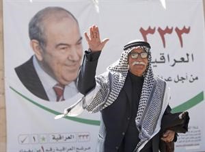 عراقي يلوح امام لافتة انتخابية تحمل صورة رئيس الوزراء العراقي السابق اياد علاوي	 اپ﻿