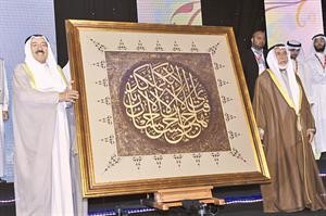 صاحب السمو الامير يتسلم هدية الجائزة من المستشار راشد الحماد وهي لوحة كتب عليها اية من القران الكريم﻿