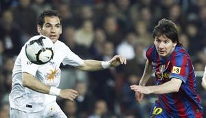 نجم برشلونة الارجنتيني ليونيل ميسي يتابع الكرة بعينيه مع لاعب اوساسونا روميرو 	رويترز﻿