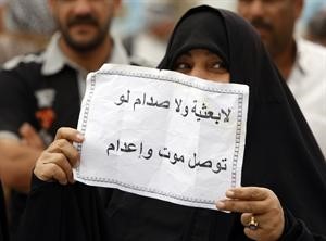 مناصرة للمالكي ترفع لافتة تعترض على نتائج الانتخابات خلال تظاهرة في بغداد امس افپ
