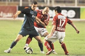 لاعبا الاهلي وائل جمعة واحمد حسن يحاصران لاعب انبي﻿