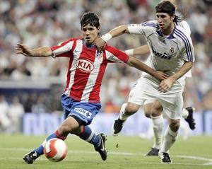 مدافع ريال مدريد سيرجو راموس يسعى لايقاف خطورة مهاجم اتلتيكو مدريد سيرجو اغويرو