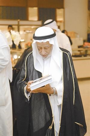 العم يوسف الحجي يطالع احدى المعروضات﻿