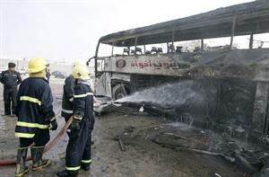 رجال الدفاع المدني يطفئون الحافلة التي استهدفها انفجار النجف امس رويترز