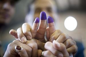 عراقيون في ايران يرفعون اصابعهم لاظهار الحبر الازرق عليها دلالة على تصويتهم في الانتخابات التشريعية امس 				رويترز﻿