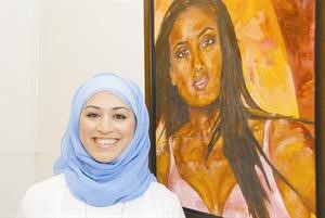 القطامي امام احدى لوحاتها
