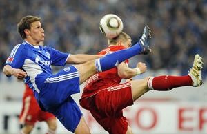 مدافع شالكه بنديكيت هودز يبعد الكرة من امام لاعب بايرن ميونيخ باستيان شفاينشتايغر 	اپ﻿