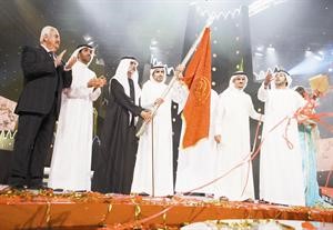 الشاعر ناصر العجمي حاملا البيرق لحظة تتويجه
