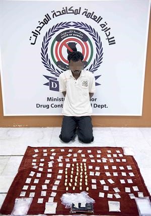 المتهم الهندي وامامه كمية الهيروين المضبوطة معه﻿