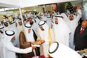 الشيخ دخالد المذكور يعرض على الشيخ احمد الفهد احد الكتب خلال الجولة بالاجنحة المشاركة اسامة البطراوي