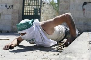 فلسطيني ملثم منبطح ارضا لتجنب الاصابة خلال مواجهات مع قوات الاحتلال الاسرائيلي في حي سلوان امس رويترز
