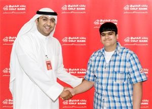 مسؤول في بنك الخليج يسلم احد الفائزين جائزته
