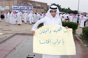 احد ابناء ام الهيمان يحمل لافتة موجهة الى نواب الدائرة الخامسة