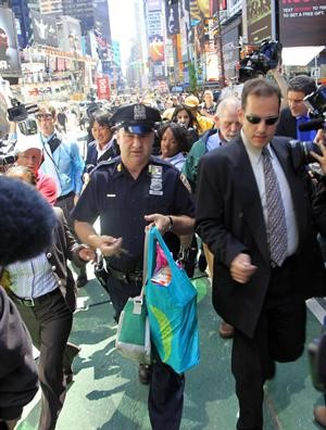 الطرد المشبوه بين يدي رجل شرطة بعد التحقق منه في ساحة تايمز سكوير في نيويورك امس		اپ