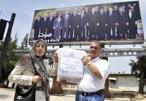 احد صناديق الاقتراع في طريقه الى مركزه وتبدو في الخلفية صورة كبيرة لقائمة وحدة بيروت