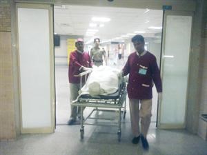 نقل الجثة الى سيارة الادلة الجنائية
