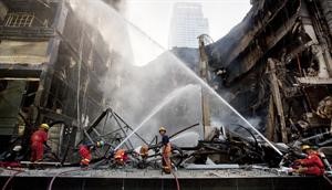 رجال اطفاء يطفئون النيران التي اضرمها المحتجون من القمصان الحمر في مول مركز العالم وسط بانكوكرويترز