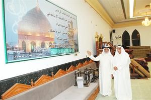 السيد احمد الخباز يطلع الزميل منصور الهاجري على لوحة بها ابيات من الشعر للشريف الرضي