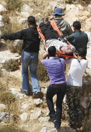 فلسطينيون يحملون مصورا فلسطينيا جرح خلال الاشتباكات مع قوات الاحتلال احتجاجا على توسيع مستوطنة في الضفةافپ