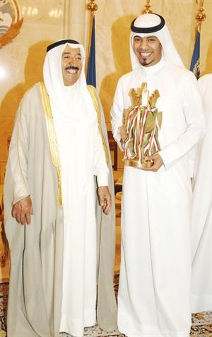 مهاجم القادسية احمد عجب يحمل كاس سمو الامير خلال لقائه صاحب السمو الامير