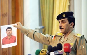 اللواء قاسم عطا يعرض صورة احد المعتقلين في المؤتمر الصحافي الذي عقده امس في بغداد رويترز