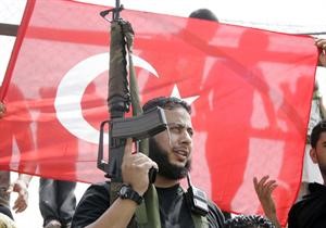 مسلح فلسطيني وخلفه العلم التركي خلال احدى مظاهرات الدعم لتركيا في عين الحلوة﻿﻿رويترز﻿