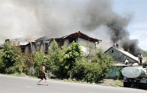 قرغيزيون يحاولون اطفاء النيران التي اجتاحت منازلهم خلال الاضطرابات امس 			اپ﻿