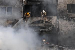 رجال الاطفاء يكافحون النيران من داخل احدى الشقق المحترقة﻿