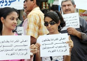 عراقيون يحملون لافتات تطالب باستجواب مسؤولي وزارة الكهرباء خلال مظاهرة احتجاجية على وضع الكهرباء في الكرادة امس 	افپ﻿
