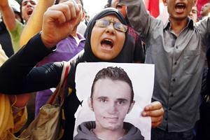 صورة ارشيفية لاحدى قريبات ضحية الاسكندرية وهي تحمل صورته في مظاهرة﻿
