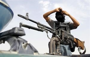 رجل امن افغاني يتلثم تحضيرا لترك موقعه العسكري	 رويترز﻿