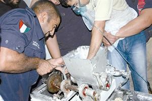 رجال الاطفاء والاسعاف اثناء محاولة تخليص يد العامل المصري من المفرمة﻿