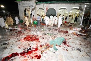 باكستانيون يقفون بجوار جثث ضحايا الانفجار في لاهور امس الاول	 افپ﻿