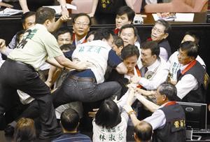 احد النواب الغاضبين يحاول الوصول الى منصة نواب الحزب التايواني	 رويترز
﻿