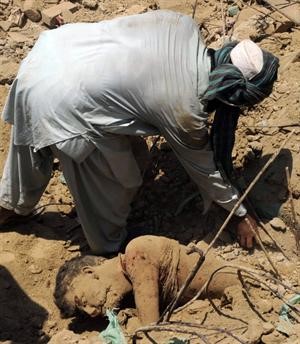 باكستاني يحاول اخراج طفل من تحت انقاض الانفجار	 افپ﻿