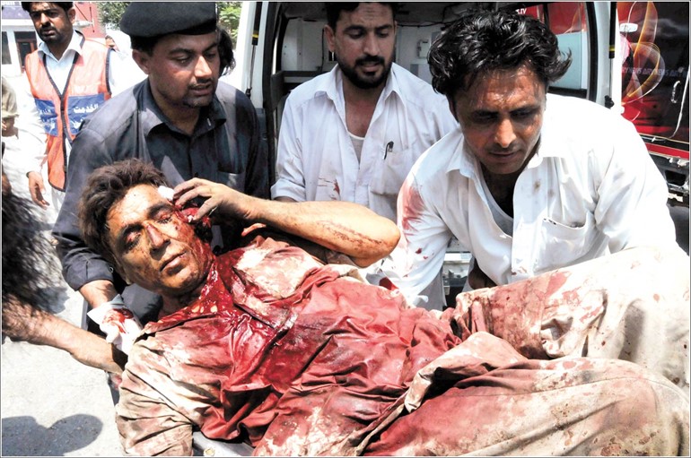 مجموعة من المتطوعين الباكستانيين يحملون احد المصابين جراء التفجير الانتحاري الى مستشفى بيشاور امسافپ