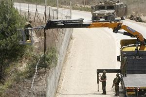 جنود اسرائيليون يستخدمون الرافعة لاجتياز الحدود
